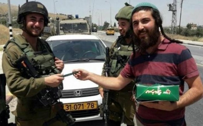 المستوطن القاتل يوزع الحلوى على جنود الاحتلال في حوارة