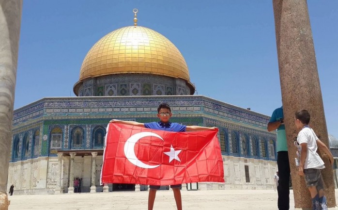 طفل فلسطيني يحمل علم تركيا في ساحات المسجد الأقصى