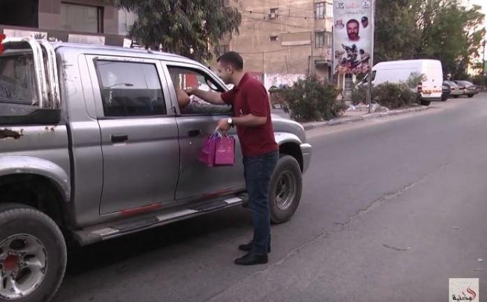 موظف من بنك فلسطين يوزع المياه والتمر على المواطنين بغزة