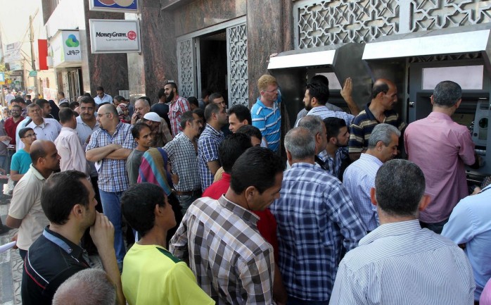 موظفون السلطة أمام بنك فلسطين في مدينة غزة ينتظرون الرواتب