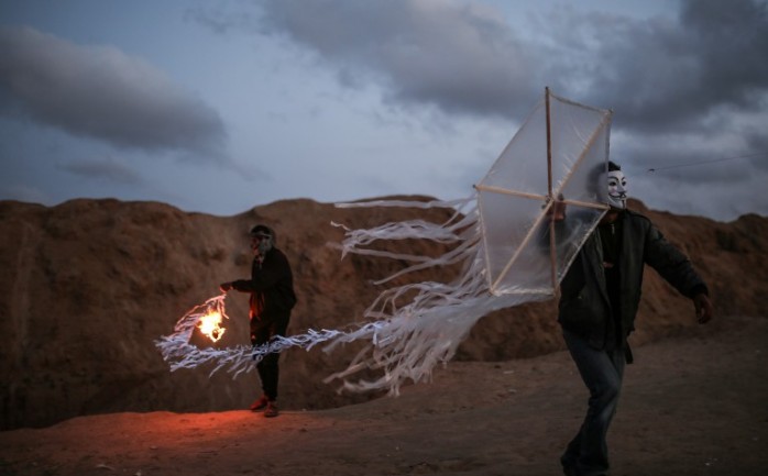 شابان يستعدان لإطلاق طائرة ورقية حارقة بتجاه مستوطنات غلاف غزة