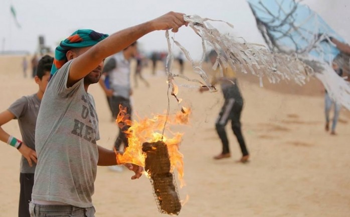 أحد الشبان على الحدود الشرقية لقطاع غزة يستعد لإطلاق طائرة ورقية حارقة