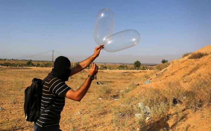 شاب فلسطيني يحاول إطلاق بالون حارق تجاه مستوطنات غلاف غزة (أرشيف)